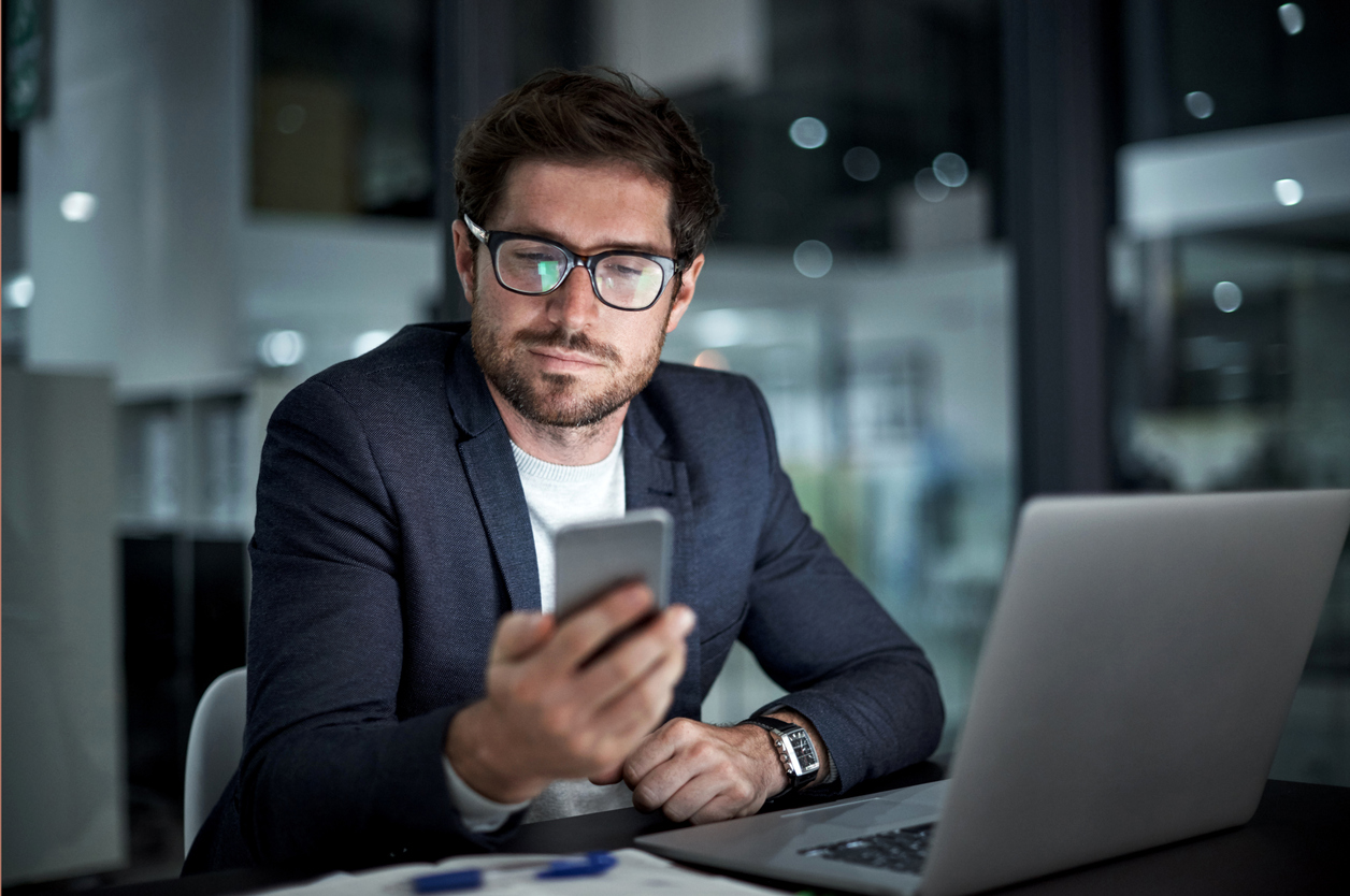 businessman-using-phone-and-laptop