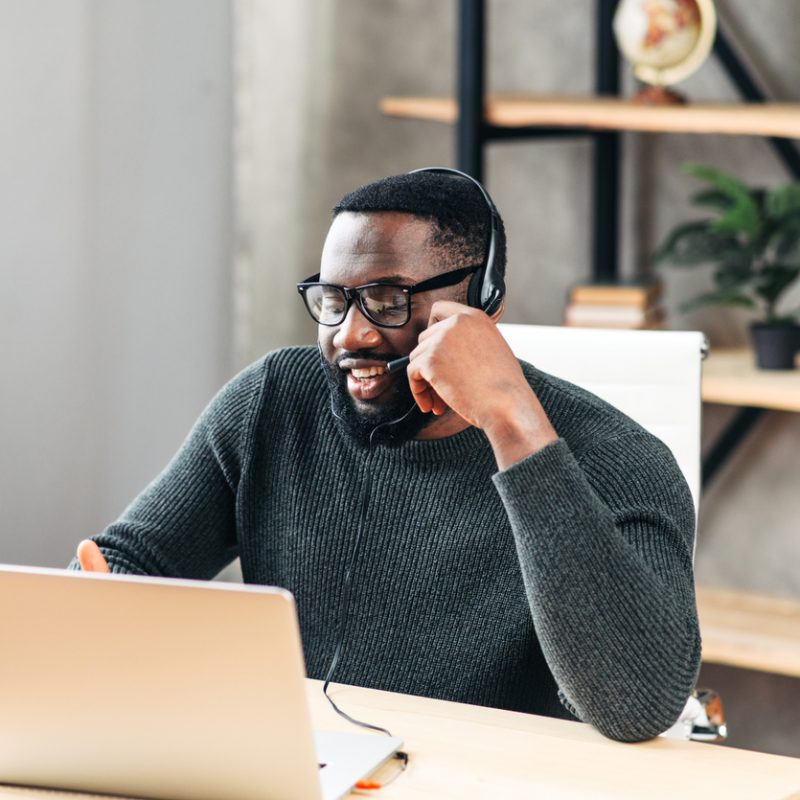 man-wearing-headset-using-laptop